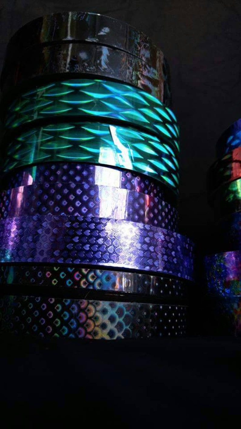 May include: Rolls of iridescent holographic vinyl tape in various colors and patterns, including green, purple, and blue.