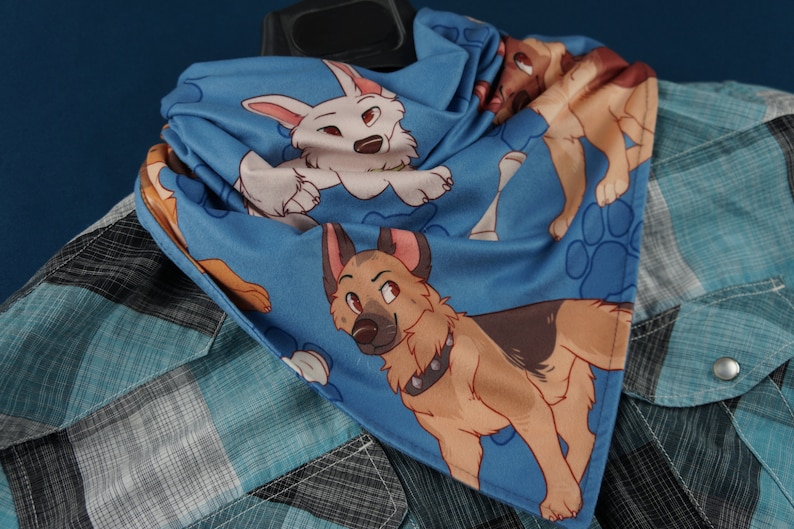 K&ouml;nnte beinhalten: Ein blaues Bandana mit einem wei&szlig;en und braunen Hundedruck. Das Bandana zeigt Pfotenabdr&uuml;cke und Knochen.