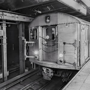 May include: A black and white photo of a subway train in a station. The train is labeled with the letter "C" and the number "5530".