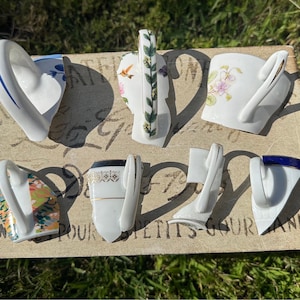 May include: A white ceramic mug with a black handle and the text "But First, Coffee" in a bold, black font. The mug is set against a blurred background, suggesting a cozy setting.