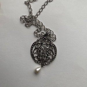 Collar vintage de cadena larga de Avon con un hermoso colgante calado y una perla artificial colgante.
