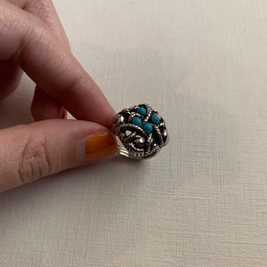 Anillo vintage Avon con cuentas de turquesa sintética caladas, texturizadas y en tono plateado, en varios tamaños.