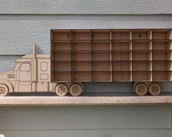 Peut inclure: Camion jouet en bois avec une remorque comportant 18 compartiments individuels pour ranger de petits objets. Le camion est peint en brun et présente un design détaillé.