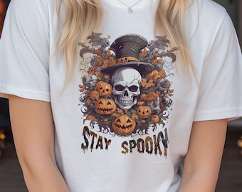 May include: White t-shirt with a Halloween-themed graphic. The design features a skull wearing a top hat, surrounded by pumpkins and bats. The words "Stay Spooky" are printed below the graphic.