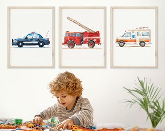 May include: Three framed watercolor illustrations of emergency vehicles. The illustrations are of a police car, a fire truck, and an ambulance. The illustrations are on a white background and are framed in natural wood frames.