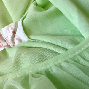May include: A light green nylon nightgown with a lace trim and a label that reads "Berry's Size Med 35".
