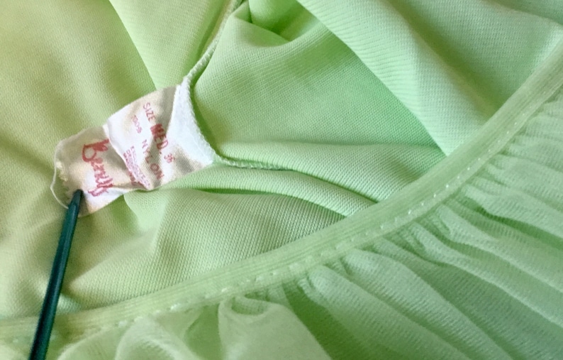 May include: A light green nylon nightgown with a lace trim and a label that reads "Berry's Size Med 35".