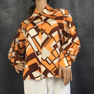 May include: A long-sleeved button-up shirt with a geometric pattern in orange, brown, and white.