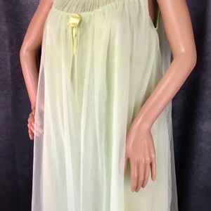 May include: A pale green sheer nightgown with a gathered neckline and a yellow satin bow.