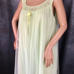 May include: A light green sheer nightgown with a yellow satin bow at the neckline.