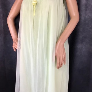 May include: A pale yellow sheer nightgown with a gathered neckline and a small yellow flower accent at the center.