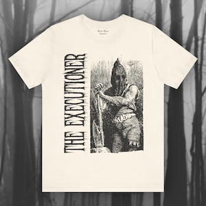 May include: A white t-shirt with a black and white illustration of a hooded figure holding an axe. The text "THE EXECUTIONER" is printed vertically on the left side of the image.