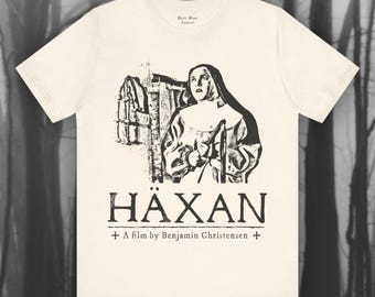 May include: A white t-shirt with a black and white image of a woman in a nun's habit. The text "HÄXAN + A film by Benjamin Christensen +" is printed below the image.