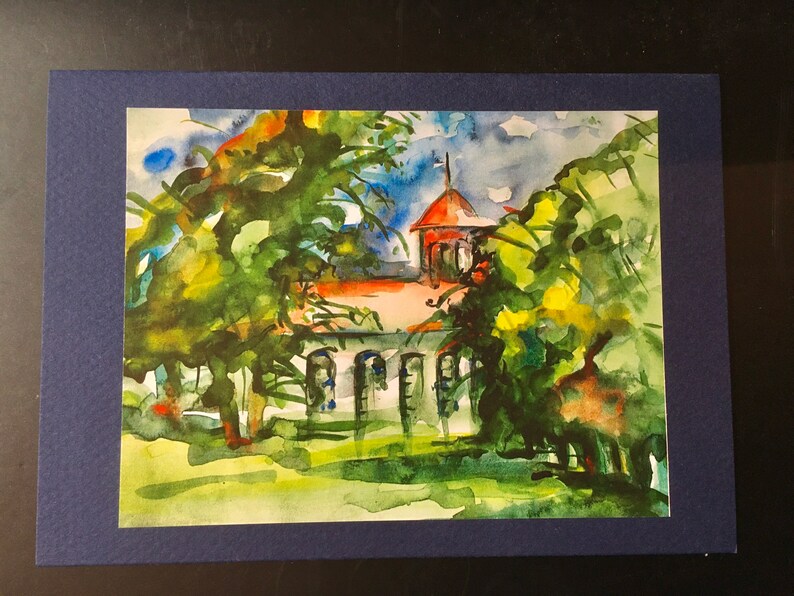 Pu&ograve; includere: Dipinto ad acquerello di un edificio in mattoni rossi con una torre, circondato da alberi verdi. L'edificio ha finestre bianche e un tetto rosso. Il dipinto &egrave; incorniciato da una cornice blu scuro.