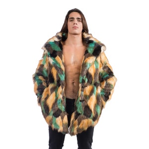 Puede incluir: Una persona lleva un abrigo de piel sintética de manga larga, multicolor, con un patrón geométrico en tonos de verde, marrón y amarillo. El abrigo está abierto, dejando ver un pecho desnudo y unos vaqueros negros. La persona lleva botas negras.