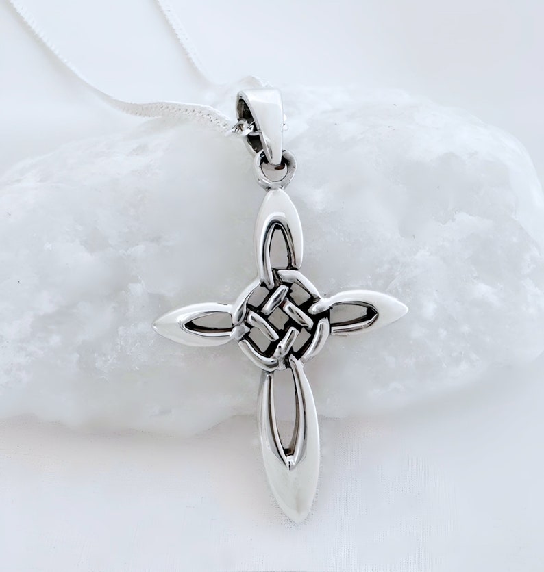 May include: A silver Celtic knot cross pendant necklace. The cross is made of a woven knot design and hangs from a silver chain.