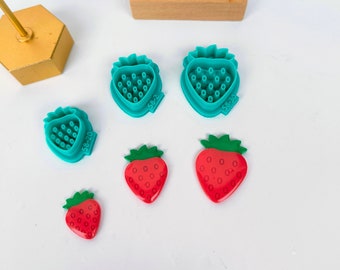 Peut inclure: Cinq emportes-pièces en forme de fraise, deux grands, deux moyens et un petit. Les emportes-pièces sont bleu turquoise avec un motif en relief de fraise. Les deux grands emportes-pièces portent les numéros 58-22 et 58-30. Il y a aussi trois fraises en plastique rouge avec un motif en relief de fraise.