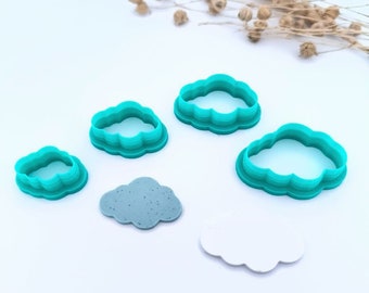May include: Set of four turquoise plastic cloud-shaped cookie cutters of varying sizes. Two gray and one white cloud-shaped cookie are also shown.