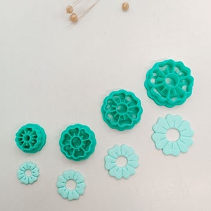 Peut inclure: Ensemble de six emporte-pièces en forme de fleur en plastique turquoise de différentes tailles.