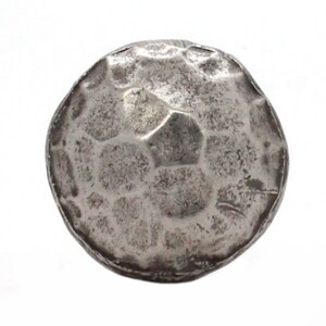 May include: A silver coin with a hammered, textured surface. The coin is round and has a raised rim.