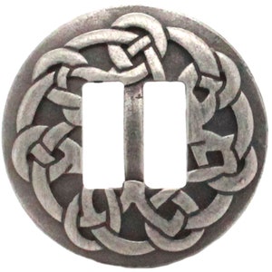 May include: A silver-toned metal buckle with a Celtic knot design. The buckle has two slots for a belt or strap.