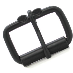 May include: Black metal buckle with a roller closure. The buckle has a rectangular shape with rounded corners.