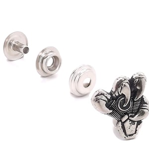 May include: Silver metal snap fasteners with a decorative silver metal lobster claw design.