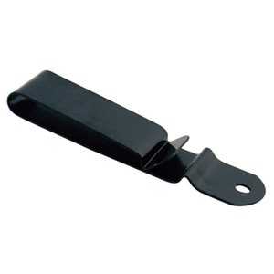 May include: A black metal belt clip with a curved top and a flat, rectangular body. The clip has a small, pointed tab and a rounded end with a hole. The object is designed to hold a belt.