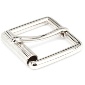 May include: A shiny, silver-colored metal buckle with a textured roller bar. The buckle has a rectangular frame and is designed for use with belts or straps. The roller bar is detailed with a crosshatch pattern.