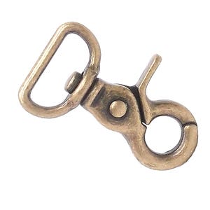 May include: Antique gold metal swivel clasp with a D-ring. This clasp is perfect for attaching to bags, straps, or other accessories.
