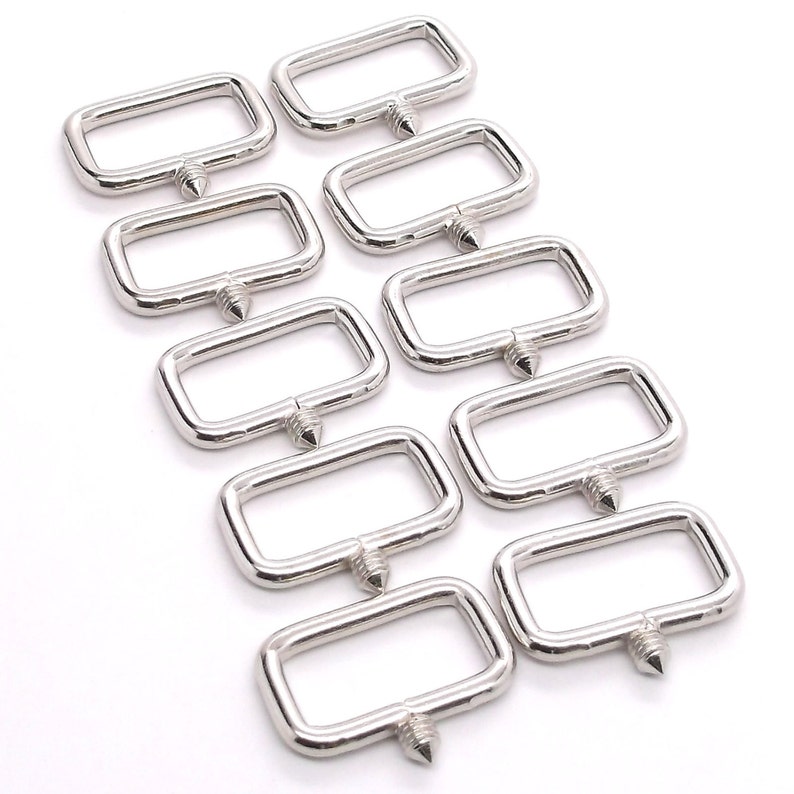 Puede incluir: Diez anillos en D de metal plateado con un extremo puntiagudo. Los anillos est&aacute;n dispuestos en forma escalonada.