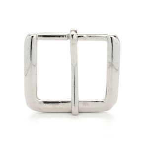 May include: A silver metal buckle with a rectangular shape and a smooth finish.