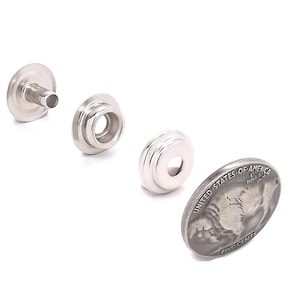 May include: Three silver metal snap fasteners, one with a post, one with a socket, and one with a cap, next to a US five-cent coin.