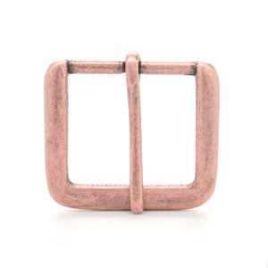 May include: A copper-toned metal buckle with a rectangular shape and a smooth finish.