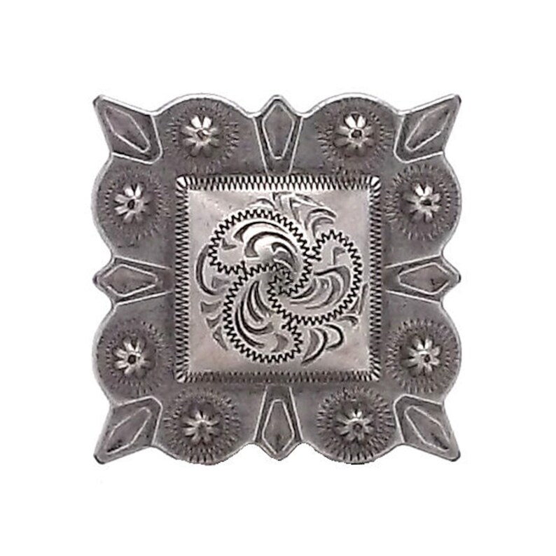 May include: Silver-toned metal concho with a decorative floral design. The concho has a square shape with rounded corners and a raised center design.