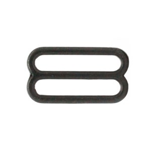 May include: Black metal slider buckle for sewing projects. The buckle has two loops.