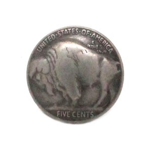 May include: A silver-colored coin featuring a detailed profile of a bison on one side. The coin is inscribed with "UNITED STATES OF AMERICA" and "FIVE CENTS". The coin has a worn appearance.