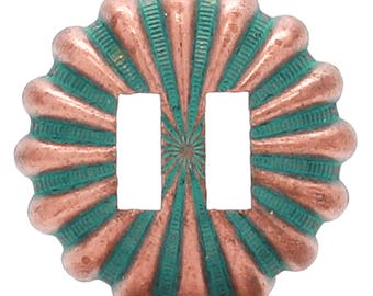 May include: A copper-colored metal buckle with a green and copper sunburst design. The buckle has two slots for a belt.