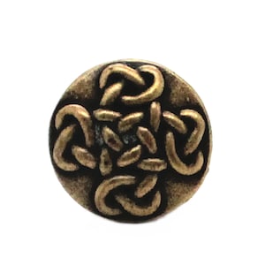 May include: A round, gold-colored button with a Celtic knot design. The knot is raised and has a textured surface.