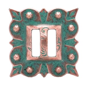 May include: A copper-colored metal buckle with a green patina. The buckle has a square shape with rounded corners and a double-loop design. The buckle is decorated with a floral pattern and small raised dots.