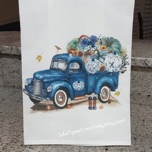 May include: A blue vintage pickup truck with a white heart on the side is filled with pumpkins, gourds, and fall flowers. The truck is on a white background with the text "IdleTymeCreations.etsy.com" at the bottom.
