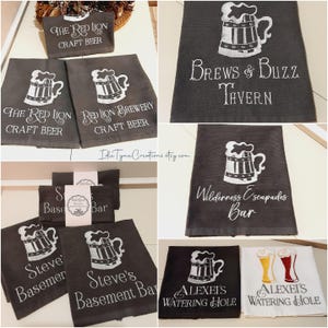 May include: A collection of dark gray and white kitchen towels featuring embroidered beer mug graphics and custom text including The Red Lion Craft Beer, Brews & Buzz Tavern, Wilderness Escapades Bar, Steve's Basement Bar, and Alexei's Watering Hole.