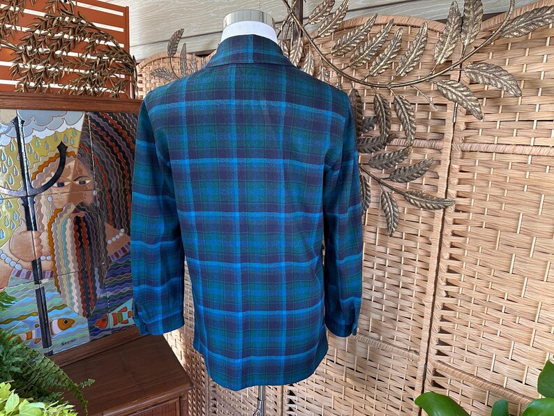 Puede incluir: Camisa de cuadros de manga larga en tonos turquesa, azul y marino. La camisa tiene un cuello cl&aacute;sico y pu&ntilde;os abotonados. El estampado de cuadros es un dise&ntilde;o tradicional.