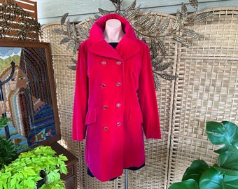 May include: A vibrant fuchsia double-breasted coat with a wide collar and large buttons. The coat has a tailored fit and is displayed on a mannequin. The coat's length extends to the mid-thigh.