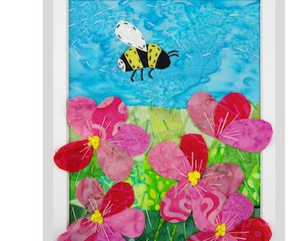 Puede incluir: Patrón de arte textil titulado "Bumblebee Among the Flowers". La obra presenta un abejorro volando sobre flores rosas con centros amarillos. El fondo es azul y verde. La pieza enmarcada mide 20 x 25 cm.