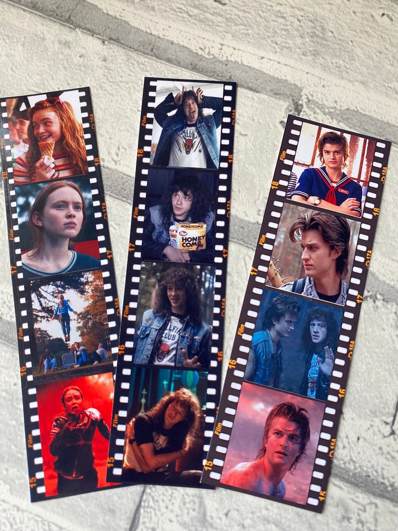 May include: A set of 3 film strip bookmarks featuring characters from the Netflix series Stranger Things. The bookmarks feature images of Eleven, Dustin, Mike, Lucas, and Steve.