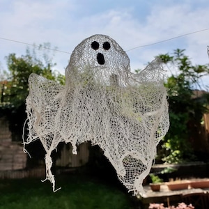 Peut inclure: Une d&eacute;coration de fant&ocirc;me en gaze blanche suspendue &agrave; une ficelle. Le fant&ocirc;me a deux yeux noirs et une bouche.