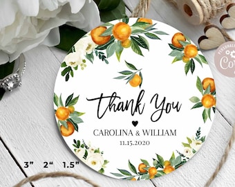 Puede incluir: Etiqueta redonda blanca de agradecimiento con una corona de flores de azahar, hojas verdes y flores blancas. El texto dice "Gracias" con un corazón y "CAROLINA & WILLIAM 11.15.2020". La etiqueta tiene un diámetro de 7,6 cm.