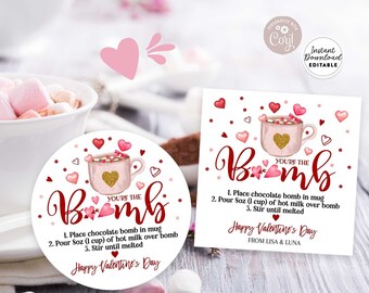 Puede incluir: Una etiqueta de regalo imprimible para el Día de San Valentín con una taza rosa y dorada llena de chocolate caliente y malvaviscos. La etiqueta dice "You're the Bomb" e incluye instrucciones para hacer chocolate caliente con una bomba de chocolate. La etiqueta también dice "Happy Valentine's Day" y tiene un diseño de corazón rosa.