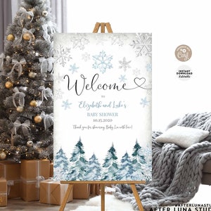 May include: Welcome sign for a winter themed baby shower with a blue and white snowflake design. The sign says "Welcome to Elizabeth and Luke's Baby Shower 10.15.2020 Thank you for showering Baby L with love!"